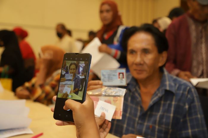 DIDATA: Warga mendapatkan bantuan langsung tunai (BLT) di Graha Barunawati, Surabaya. (SURYANTO/RADAR SURABAYA}