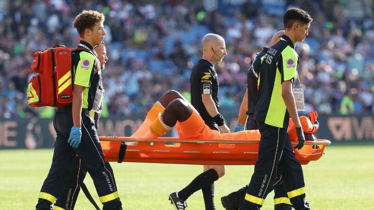 Petugas mengevakuasi Mory Diaw, kiper Clermont yang terluka akibat lemparan kembang api dari suporter. (BBC.COM)