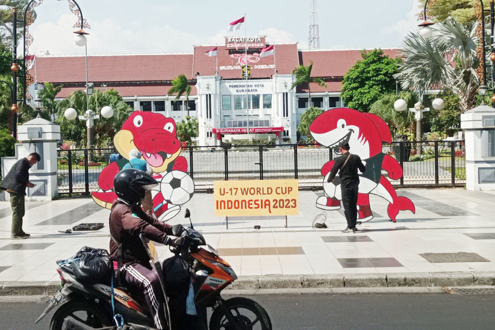 SAMBUT PILDUN U-17: Warga melintas tak jauh dari ornamen bertema Piala Dunia U-17 di depan Balai Kota Surabaya. (SURYANTO/RADAR SURABAYA)
