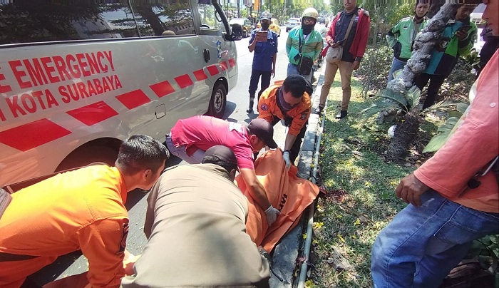 NAHAS: Petugas mengevakuasi jenazah korban Indra Yudha Permana yang mengalami kecelakaan tunggal di Jalan Mayjen Sungkono, Surabaya.  (IST)