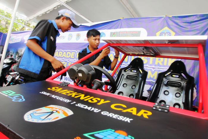 SIAP: Dua siswa SMK Negeri 1 Sidayu, Gresik, mempersiapkan mobil listrik karya mereka, sebelum mengikuti parade kendaraan listrik yang akan diikuti oleh SMK se-Jatim. (ANDY S/RADAR SURABAYA)