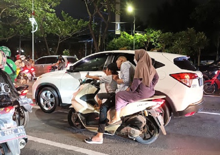 MELANGGAR: Berkendara dengan membonceng istri sekaligus anak di jalur utama Surabaya tanpa helm seperti ini, memiliki risiko yang sangat tinggi. (GUNTUR IRIANTO/RADAR SURABAYA)