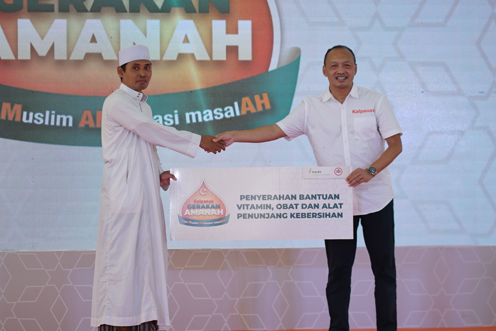 Kusnanto Pramono (kanan), GM Commercial Kalbe Consumer Health menyerahkan secara simbolik bantuan vitamin, obat dan alat kebersihan kepada Ustad Nur Hasyim, Pimpinan PP Assalafi Al Fitrah Semarang.