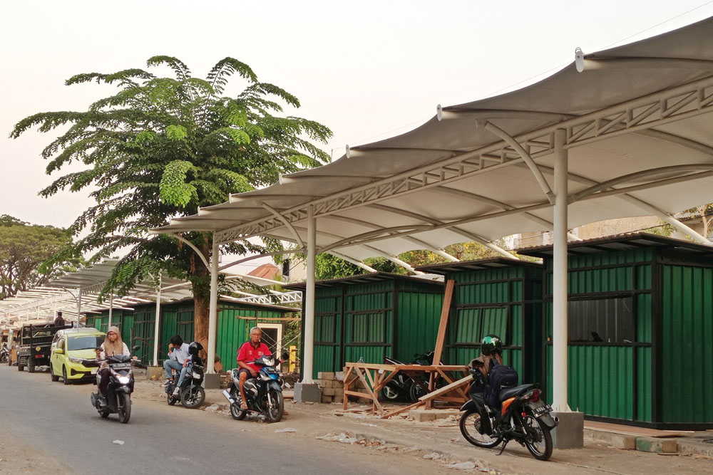 DIBENAHI: Pengendara kendaraan bermotor melintas tak jauh dari lokasi SWK Srikana, Surabaya. (SURYANTO/RADAR SURABAYA)