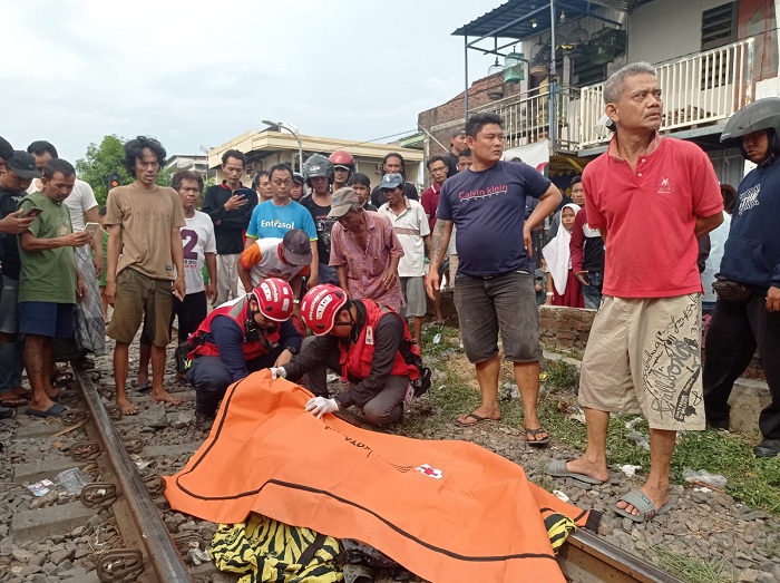 TUNGGU EVAKUASI: Mayat Dewi Aisyah, 59, warga Mojoroto, Kediri yang menabrakan tubuhnya ke KA di perlintasan Jalan Ngaglik, Surabaya, Kamis (23/11). (ISTIMEWA)