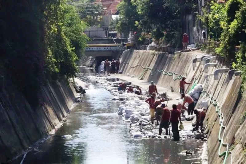 Warga membersihkan saluran air mengantisipasi musim hujan.