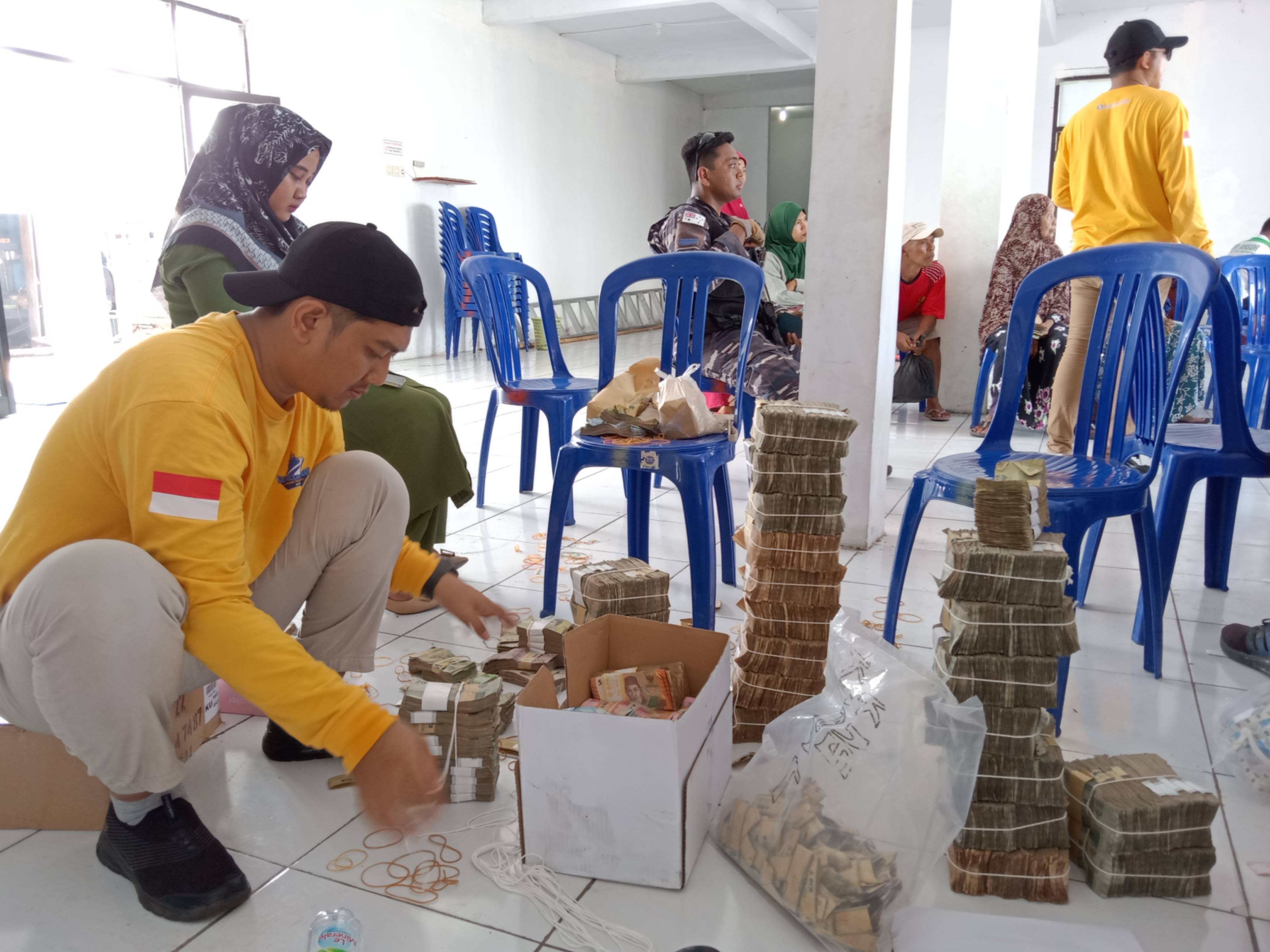 TELITI: Petugas Bank Indonesia merapikan uang lusuh dan rusak pada Kegiatan Kas Keliling Kepulauan 3T KPw Bank Indonesia Provinsi Jatim di Pulau Sapeken, Kabupaten Sumenep, Jum