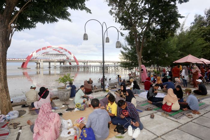 SANTAI: Sejumlah pengunjung menikmati waktu santai mereka bersama keluarga di tepi pantai Kenjeran, Surabaya. (SURYANTO/ADAR SURABAYA)
