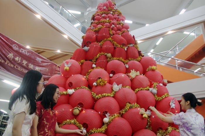 POHON NATAL LAMPION: Mahasiswa Petra University Christian (UK Petra) Surabaya, merapikan pohon natal yang disusun dari ratusan lampion untuk menyambut peringatan Natal 2023. (ANDY S/RADAR SURABAYA)