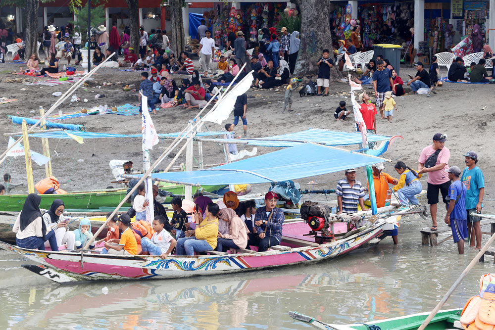 WISATA PERAHU: Sejumlah wisatawan siap berlayar dengan perahu di kawasan Pantai Kenjeran, Surabaya.