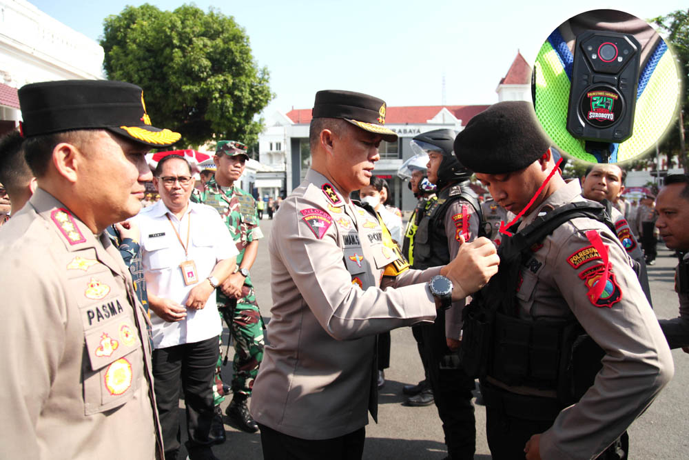 SIMBOLIS: Kapolda Jatim Irjen Pol Imam Sugianto didampingi Kapolrestabes Surabaya Kombes Pol Pasma Royce memasangkan body camera ke personel kepolisian di halaman Mapolrestabes Surabaya.