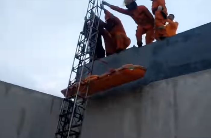 NAHAS: Petugas Rescue mengevakuasi mayat korban JB dari atas lantai dua sebuah rumah di Perumahan Grand Harvest, Balas Klumprik, Wiyung, Surabaya, Selasa (26/12). (IST)