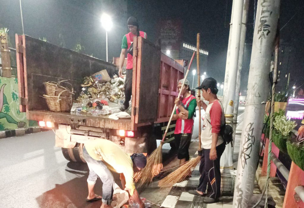 GERAK CEPAT: Petugas DLH Surabaya gercep membersihkan sampah yang berserakan seusai perayaan tahun baru.
