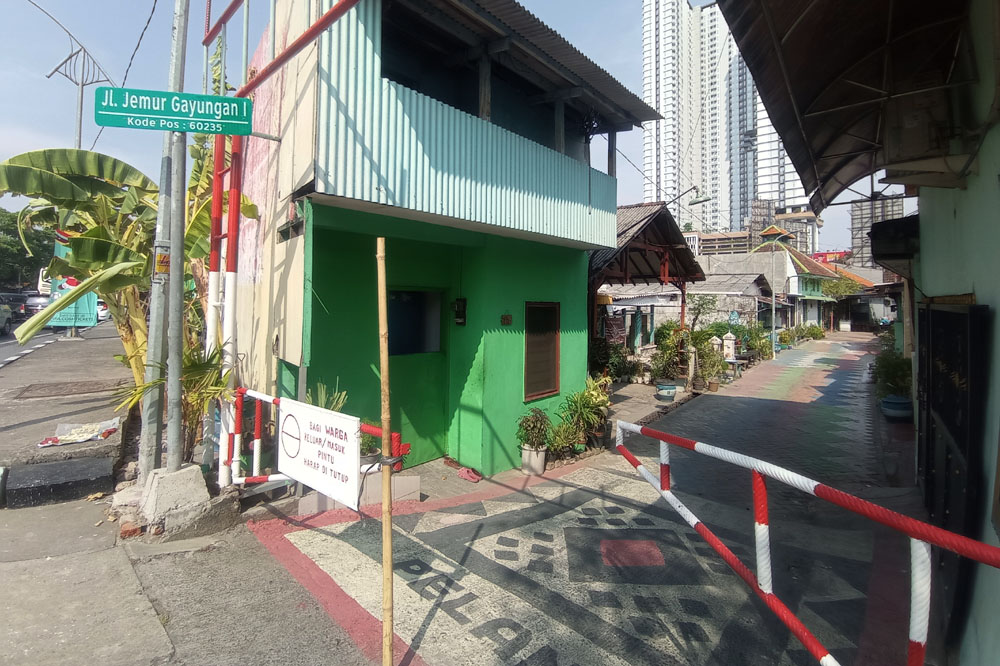 PULAU JALAN: Pengendara melintas tak jauh dari bangunan yang terimbas proyek di kawasan Taman Pelangi, Surabaya.