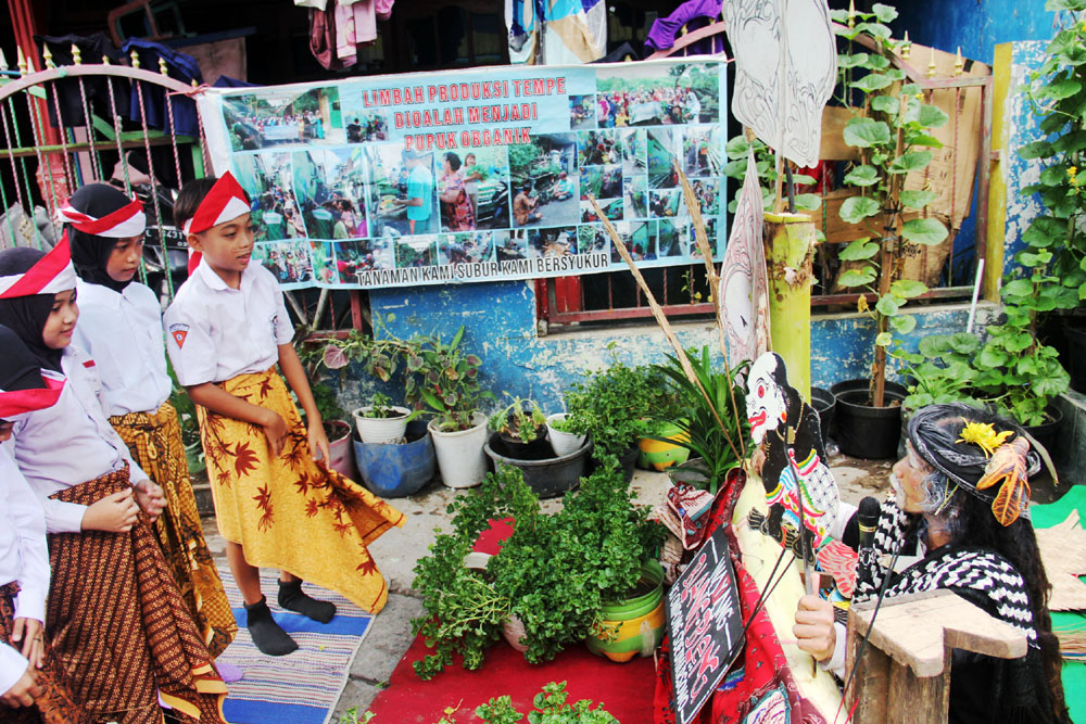 BAWA PESAN MORAL: Dalang Ki Ompong Soedharsono memainkan wayang Blang Bleng di hadapan anak-anak dan warga di kawasan Putat Jaya, Surabaya, Minggu (7/1).