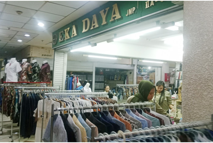 Pedagang di JMP lantai 1 menyiapkan barang dagangan di lapaknya yang masih sepi.