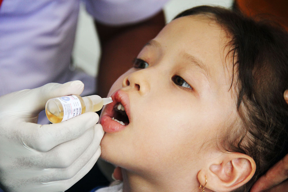 PEKAN IMUNISASI POLIO: Seorang anak mendapatkan tetesan vaksin polio oleh petugas dari Dinas Kesehatan (Dinkes) Kota Surabaya dalam pekan imunisasi serentak di Jalan Jemur Andayani, Surabaya.