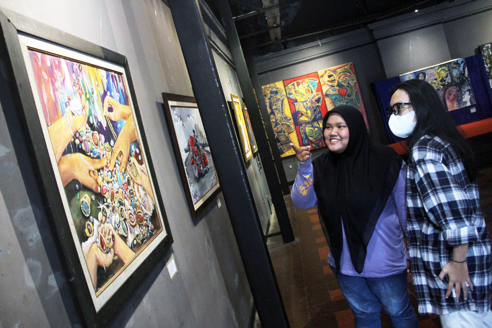 LUKISAN PEMBUKA TAHUN: Pengunjung mengamati karya lukis para perupa Jatim dengan tema Energy of Future yang dipamerkan di Galeri DKS Kompleks Balai Pemuda Surabaya, Selasa (16/1).