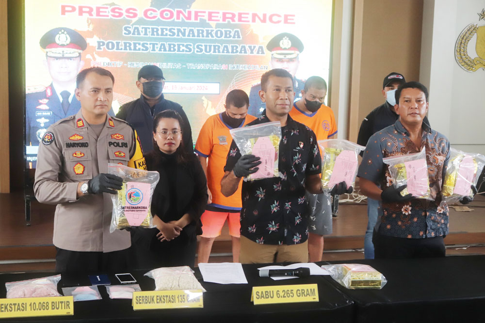 BARANG BUKTI: Polisi menunjukkan barang bukti narkoba dan dua tersangka kurir yang diamankan di Polrestabes Surabaya.