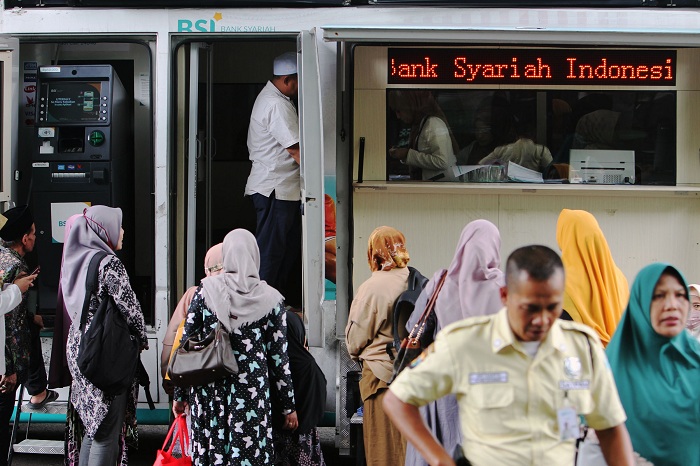 PELUNASAN: Sejumlah calon jemaah haji Jatim lakukan pembayaran pelunasan biaya haji lewat mobil kas keliling BSI yang berada di area Asrama Haji Sukolilo Surabaya, Selasa (22/1). (ANDY S/RADAR SBY)