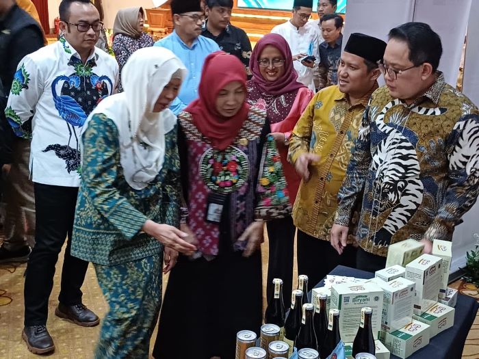 MENARIK: Ketua OPOP Jatim Adhy Karyono (kanan) memperhatikan salah satu proudk yang dihasilkan pondok pesantren di Jatim di program OPOP. (MUS P/RADAR SURABAYA)