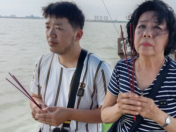 RITUAL: Umat Tri Dharma melakukan ritual di atas kapal sebelum prosesi larung di Selat Madura. (RAHMAT S/RADAR SURABAYA)
