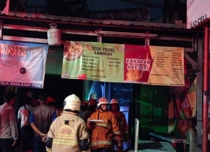 HANGUS: Petugas DPKP saat melakukan pemadaman di warung Jalan Raya Kendangsari Industri, Surabaya, Minggu malam (4/2). (IST)