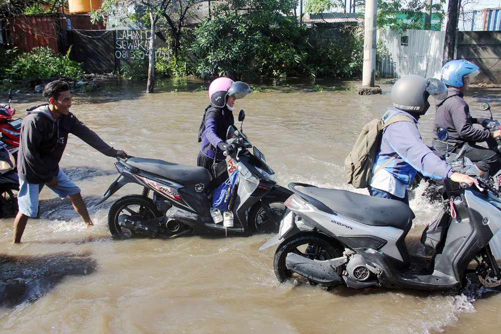 MOGOK: Beberapa motor mogok akibat genangan air yang tinggi Jalan Tambak Oso Wilangun, Surabaya.