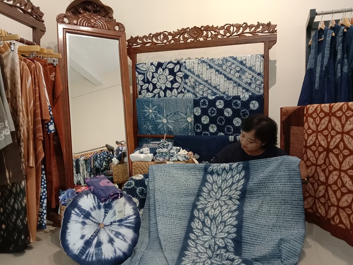 DIMINATI: Veni Rosita saat memamerkan batik shibori buatannya yang berwarna biru. (RAHMAT S/RADAR SURABAYA)