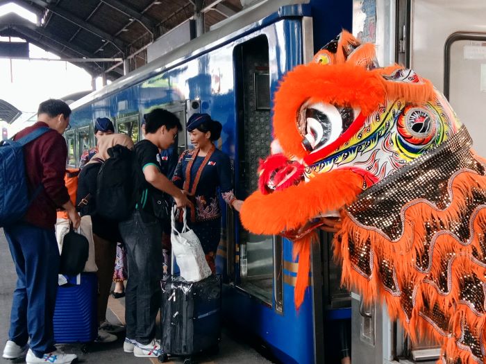MENARIK: Aksi barongsai keluar dari salah satu gerbong kereta api di Stasiun Surabaya Gubeng, Sabtu (10/2). (RAHMAT S/RADAR SURABAYA)