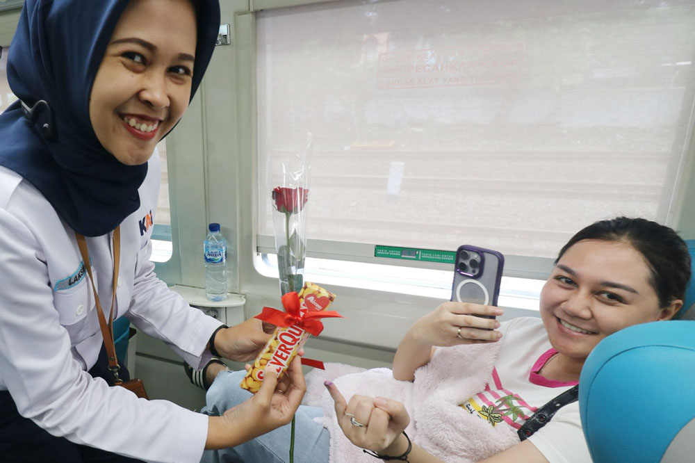 TANDA KASIH SAYANG: KAI Daop 8 Surabaya membagikan ratusan cokelat dan bunga kepada penumpang di momen hari valentine.