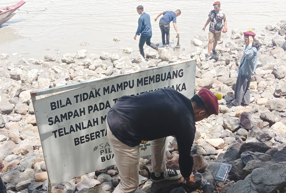 PUNGUT SAMPAH: Sejumlah mahasiswa melakukan aksi bersih-bersih di Pantai Kenjeran.