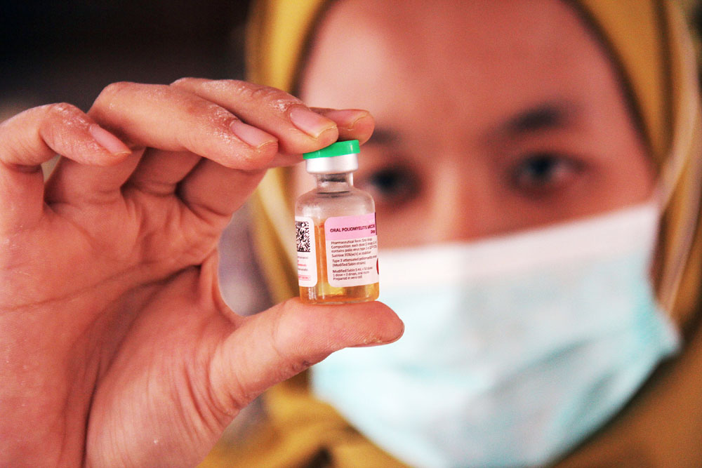 BIAR SEHAT: Seorang tenaga kesehatan (nakes) menunjukkan vaksin yang dipakai dalam imunisasi polio.