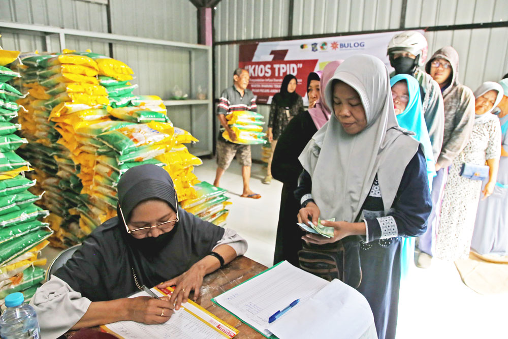 ANTRE BERAS: Sejumlah warga antre untuk mendapatkan beras murah di Pasar Pucang, Surabaya.