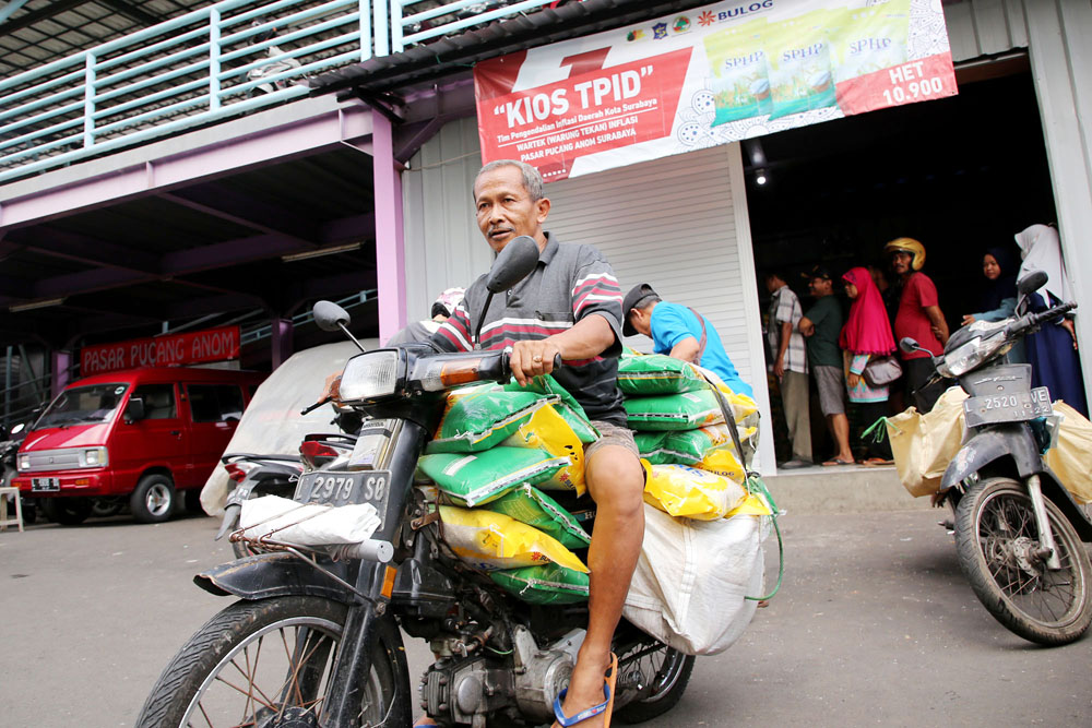 LUMAYAN: Warga membeli beras dengan harga terjangkau di kios Tim Pengendali Inflasi Daerah (TPID) di Pasar Pucang, Surabaya, Selasa (20/2).