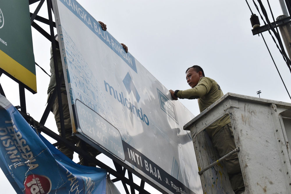 TEGAS: Petugas Satpol PP mencopot salah satu reklame di Surabaya.