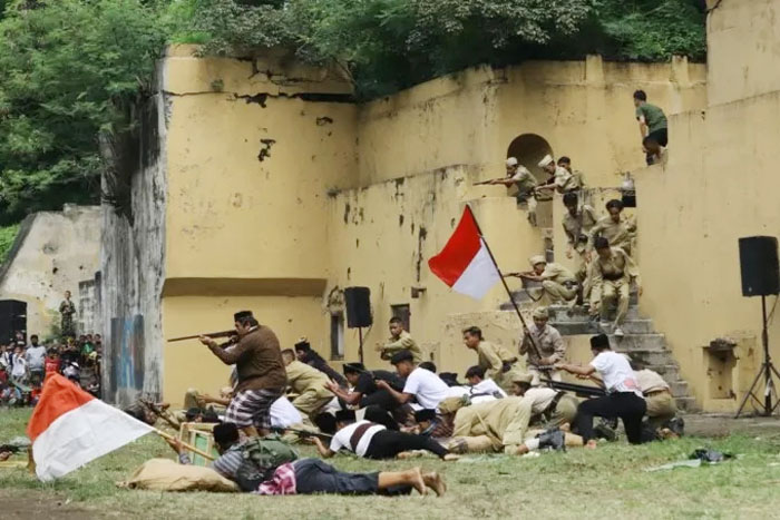 ANGKAT SENJATA: Anak-anak muda dari komunitas sejarah Surabaya menampilkan teatrikal Merebut Benteng Kedung Cowek Surabaya, Minggu (20/11/2022). (SURYANTO/RADAR SURABAYA)