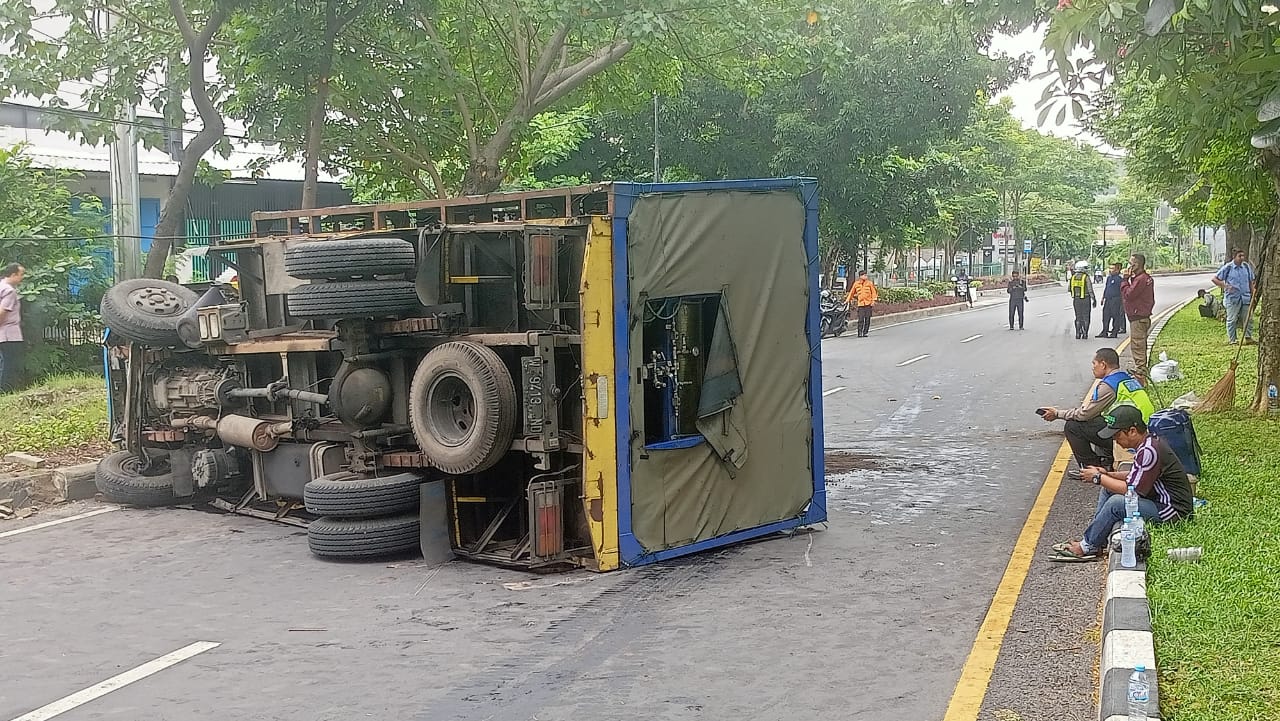 Truk bermuatan tabung gas terguling di tengah jalan kawasan MERR Surabaya.