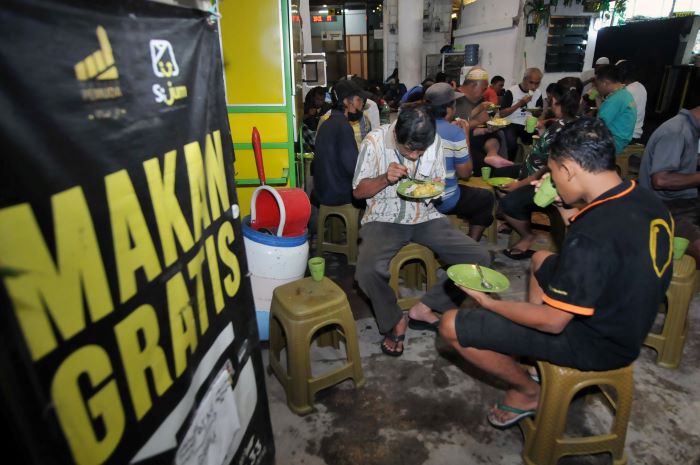 LAHAB: Sejumlah warga menikmati sajian makan gratis yang disediakan oleh pengurus Masjid Pemuda Konsulat Surabaya, ketika waktu berbuka puasa, Selasa (12/3). (ANDY S/RADAR SURABAYA)