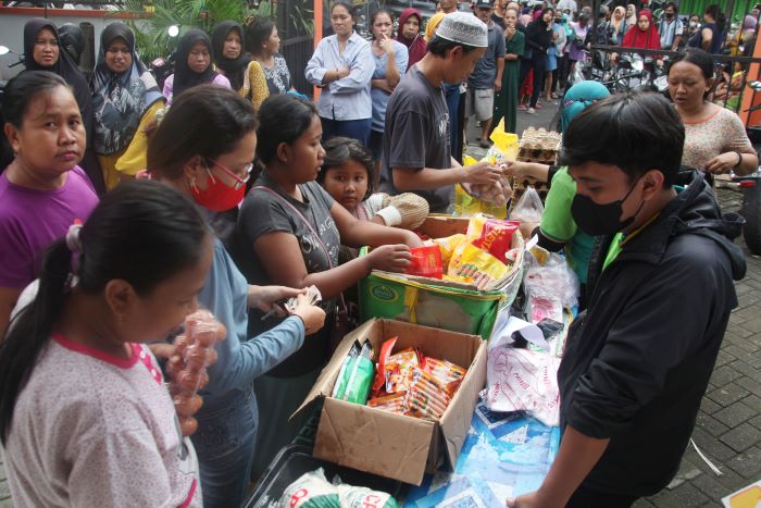 ANTRE: Warga antre membeli sembako dengan harga terjangkau di Pasar Murah yang digelar Pemkot Surabaya di halaman kantor Kelurahan Putat Jaya, Surabaya, Selasa (12/4). (SURYANTO/RADAR SURABAYA)