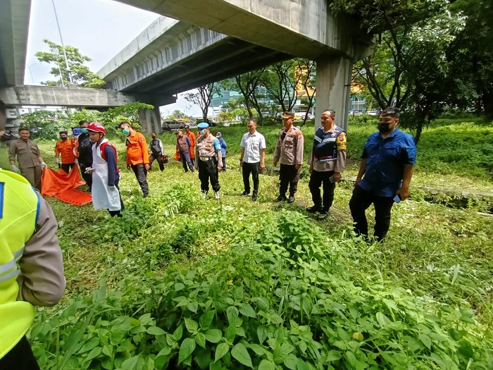 SIAP: Sejumlah petugas bersiap mengevakuasi kerangka mayat berjenis kelamin laki-laki yang ditemukan di tengah taman Bundaran Waru, Surabaya, Senin (18/3). (MAHRUS/RADAR SURABAYA)