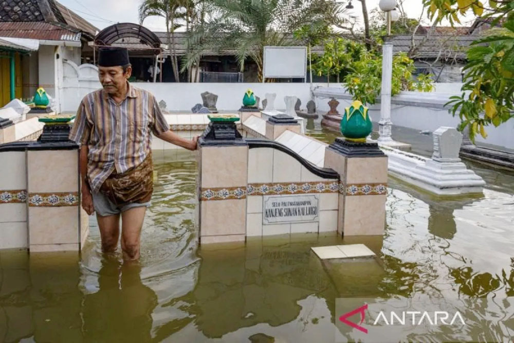 Warga berjalan di antara nisan makam yang ada di kompleks pesarean Sunan Kalijaga di Kadilangu, Demak.