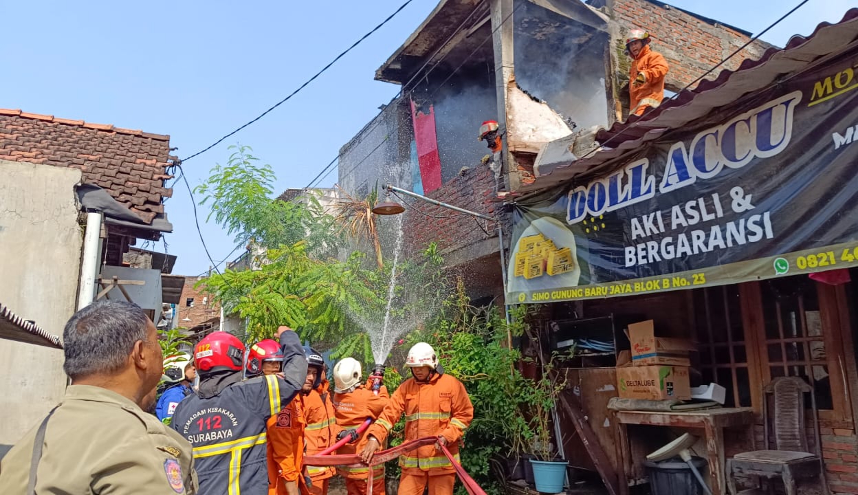 HANGUS: Petugas melakukan pembasahan di rumah Jalan Simo Gunung Baru Jaya, Kamis (21/3).