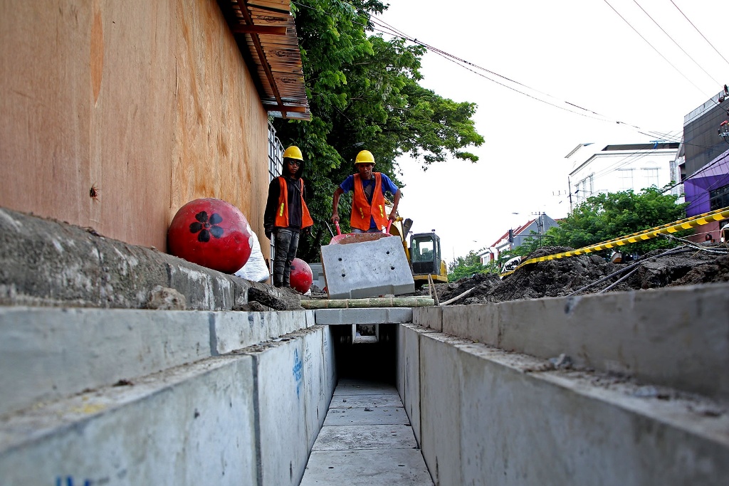 BIAR RAPI: Pekerja menyelesaikan box culvert untuk penempatan kabel utilitas bawah tanah di Jalan Kembang Jepun, Surabaya, Kamis (21/3).