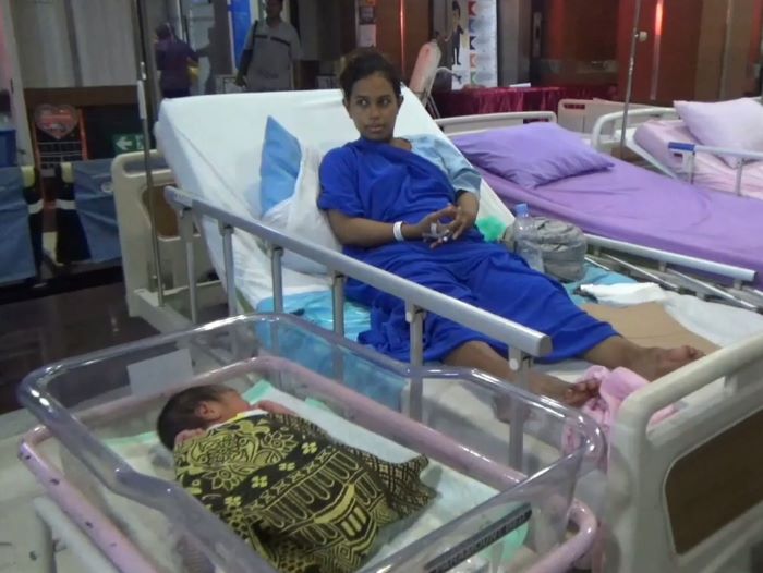 MENGHARUKAN: Nuraini dan bayinya, Muhammad Abidar Al Fatih saat di dalam gedung RSUA Surabaya, pasca evakuasi di dalam tenda darurat, Sabtu (23/3). (RAHMAT S/RADAR SURABAYA)