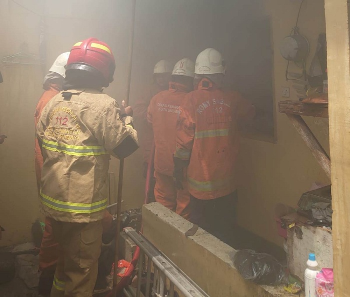BERJIBAKU: Petugas Dinas Pemadam Kebakaran dan Penyelamatan (DPKP) Surabaya bekerja keras memadamkan api yang membakar rumah kos di Jalan kejawan Putih tambak Surabaya, Senin (25/3). (IST)