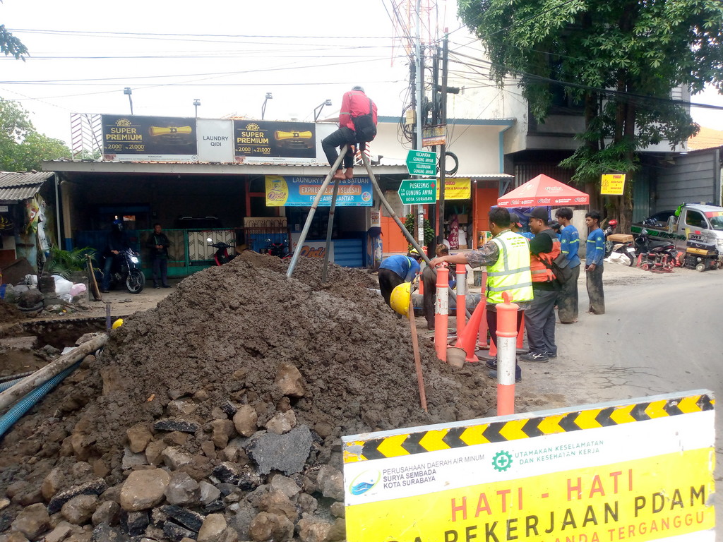 Pengerjaan jaringan pipa PDAM Surya Sembada di Jalan Kiai Abdul Karim Surabaya.