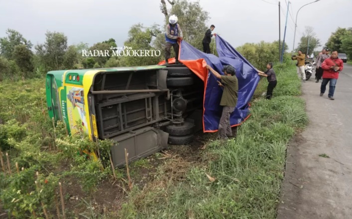 NAHAS: Bus Trans Jatim terperosok di Jalan Raya Desa Gunungsari, Kecamatan Dawarblandong, Mojokerto, Kamis (28/3). (SOFAN K/JPRM)