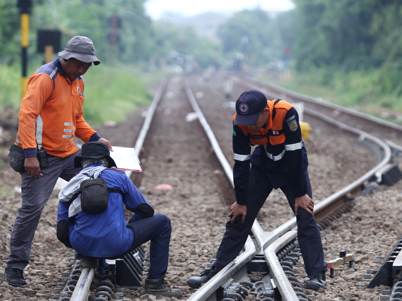 SIAGA: Petugas teknisi Daop 8 Surabaya tengah memeriksa jalur kereta api di Jalan Nias Surabaya, Sabtu (30/3).