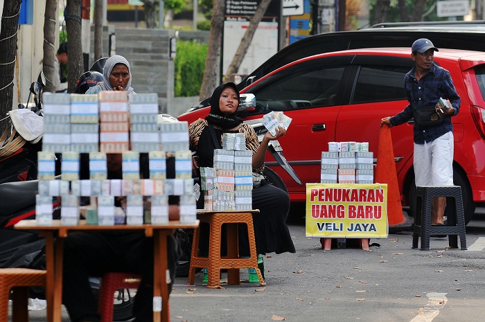 PENUKARAN UANG BARU: Sejumlah penyedia jasa penukaran uang rupiah baru, menawarkan barang mereka di sekitaran Kantor BI di sepanjang Jalan Bubutan hingga Pahlawan, Surabaya, Minggu (31/3). (ANDY S)